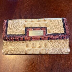 Brahmin wallet in beige with brown trim.